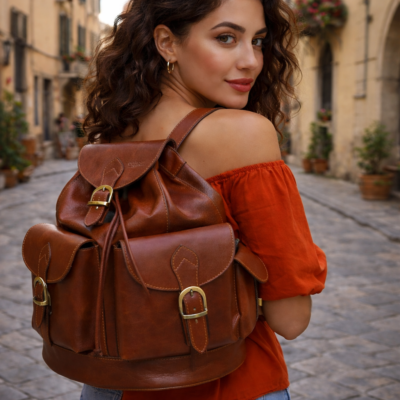בחורה איטלקיה ברחוב איטלקי עם תרמיל עור חום Old Angler Italy על הגב