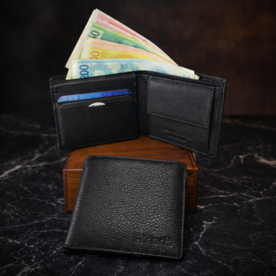 ארנק עור שחור לגבר פתוח עם שטרות ותאים לכרטיסים לצד ארנק סגור על קופסה יוקרתית
