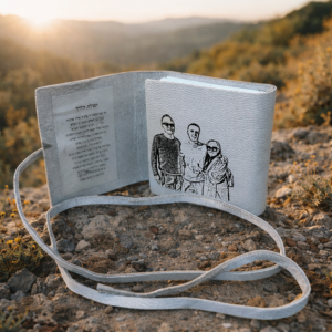 ספר תהילים מעור עם חריטת תמונה אישית, פתוח בטבע באור רך ומלא משמעות רוחנית