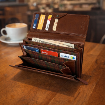 ארנק עור איטלקי פתוח עם כרטיסים ושטרות על שולחן עץ בבית קפה חמים