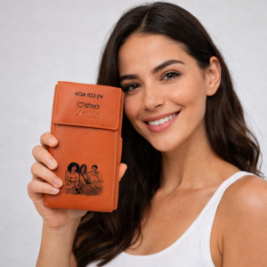 דוגמנית אוחזת בארנק עור כתום עם חריטה אישית של RUDI