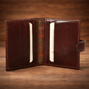 ארנק קטן לגבר מעור איטלקי חום Old Angler פתוח על רקע עץ יוקרתי