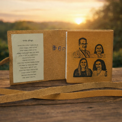 ספר תהילים מעור חום פתוח עם חריטת תמונות משפחתיות על הכריכה הפנימית