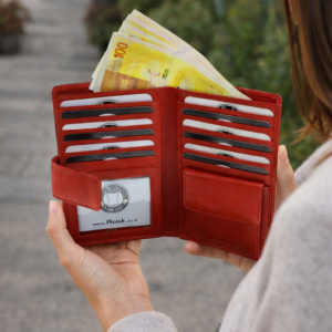 אישה מחזיקה ארנק נשים אדום מעור עם שטרות וכרטיסים – ארנק עור יוקרתי של RUDI