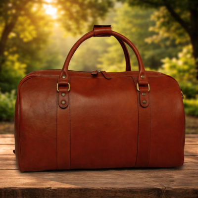 תיק דפל מעור איטלקי חום של Old Angler Italy על רקע טבע פסטורלי